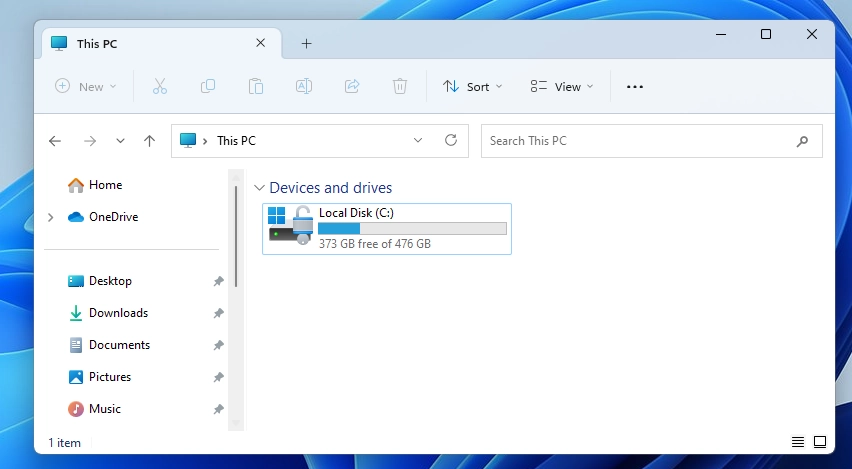 A computer user's hand on a mouse, clicking on File Explorer. The cursor is pointed at a drive icon.